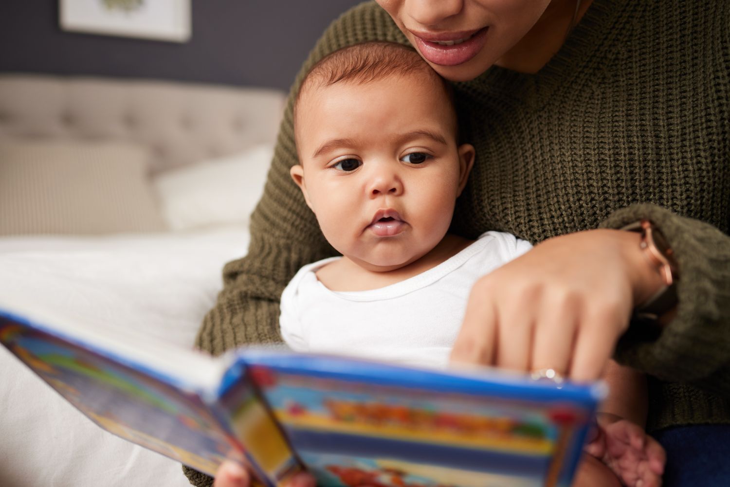 mother reading book to baby